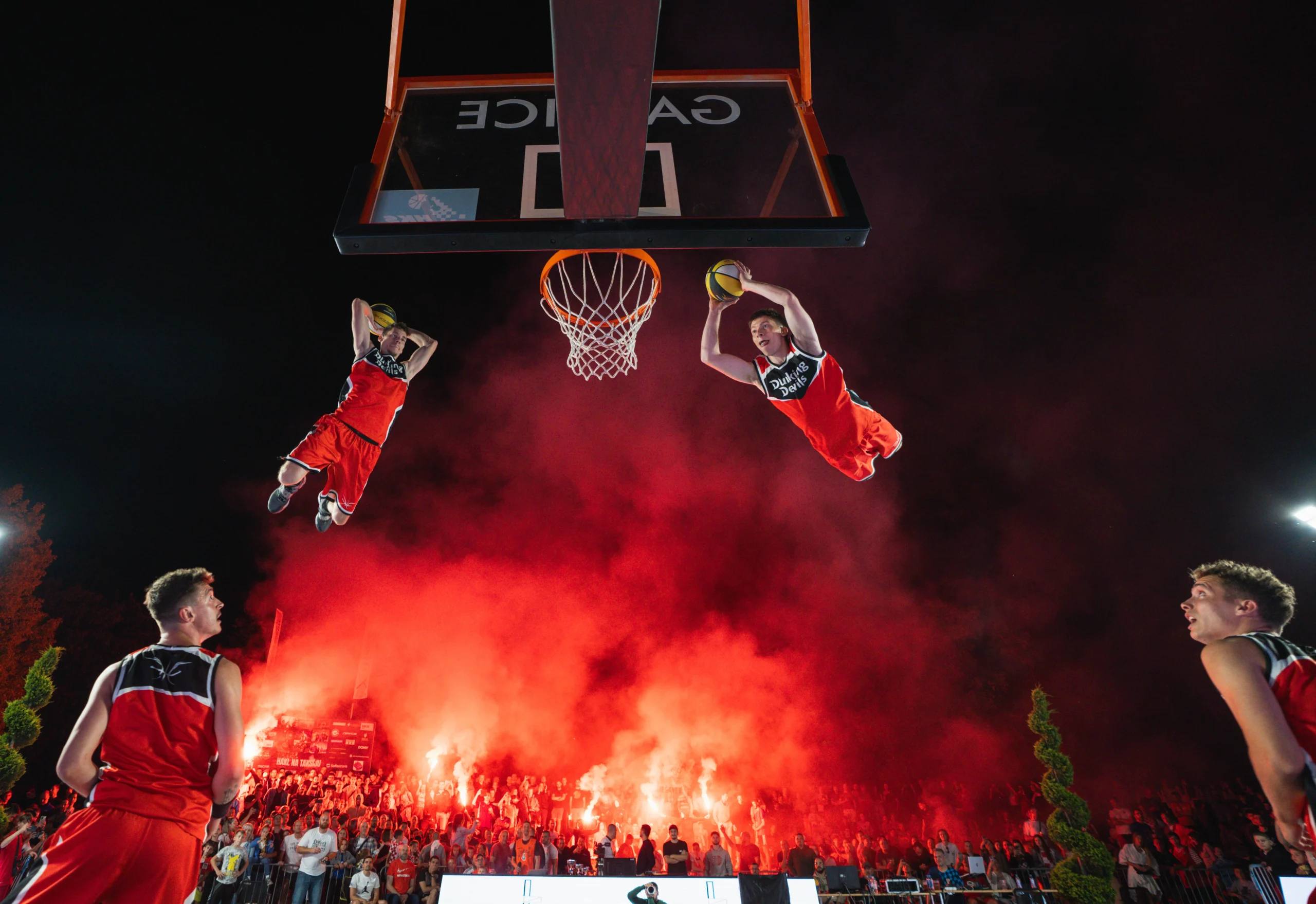 Dunking Devils performing an acrobatic dunk show outdoors.