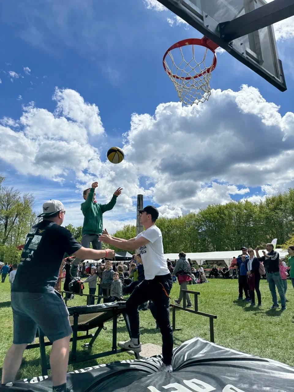 A participant flies towards the hoop at a Dunking Devils dunk workshop in a park.