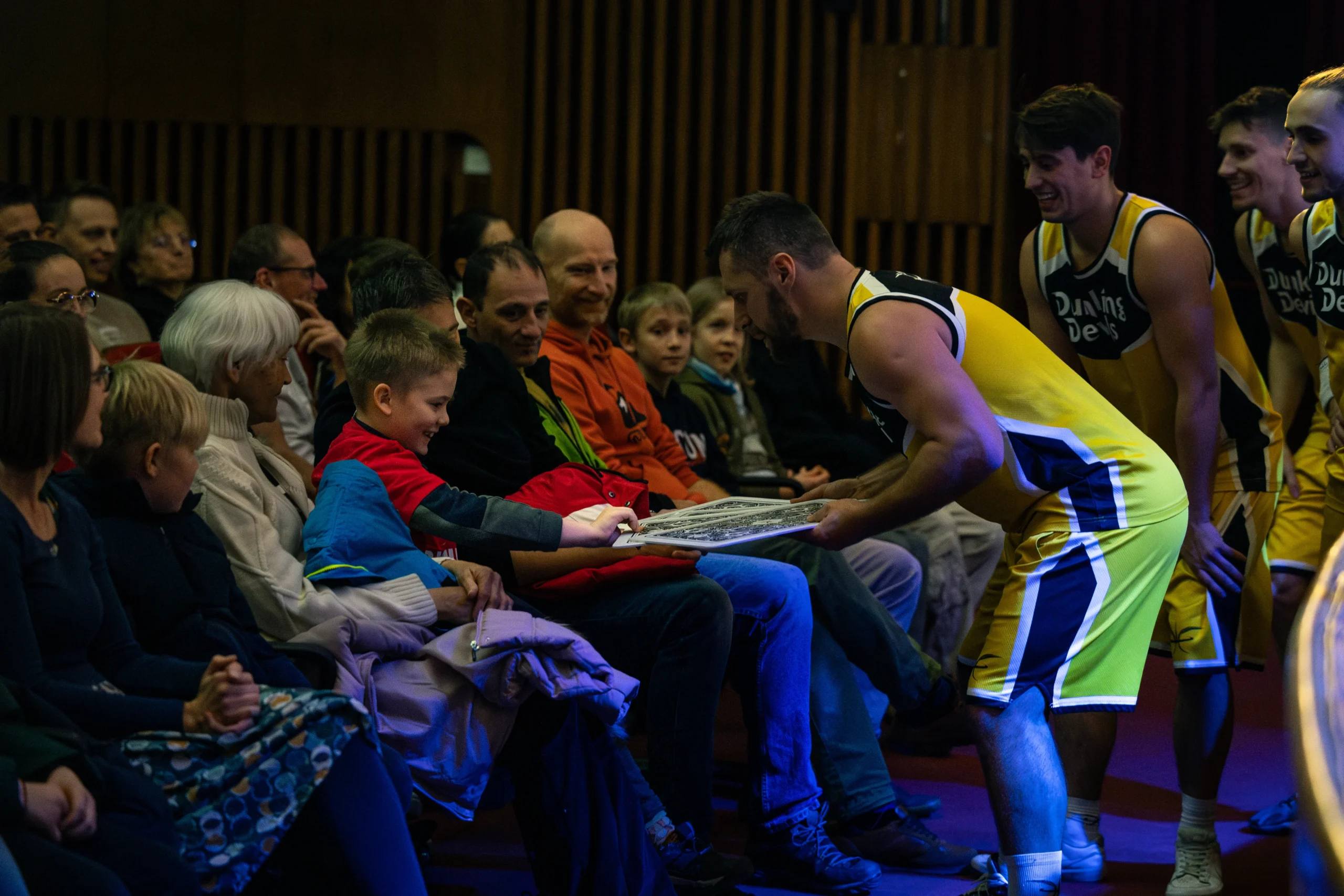 A Dunking Devils performer playing with children in the front row at Špas Teater.
