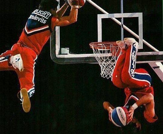 Archival photograph: two Bud Light Daredevils performers in the air at the basket, one dunking upside down.