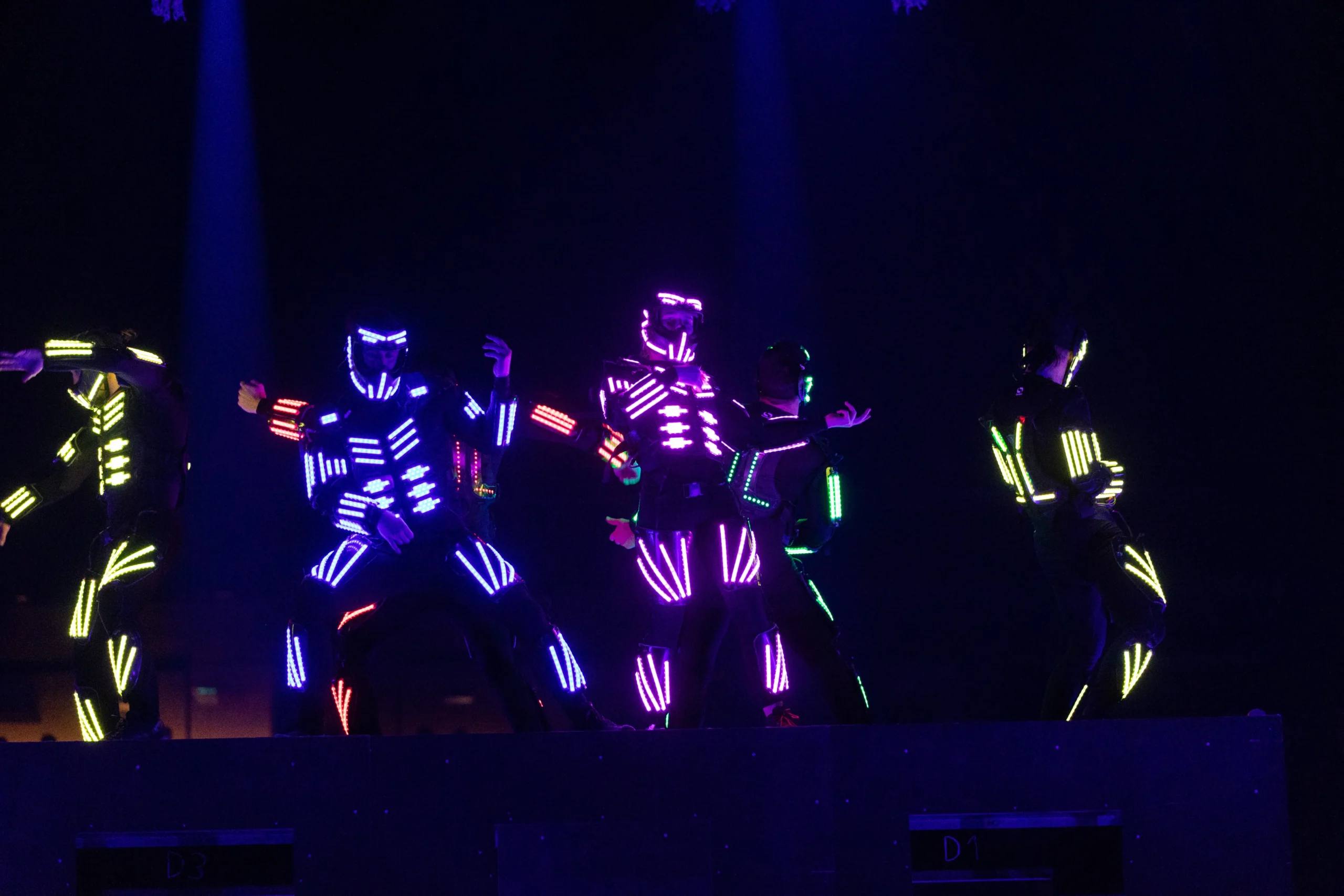 Dunking Devils LED performer mid-air in a dark venue.